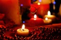 Burning red candles, heart shaped candles, ruby Ã¢â¬â¹Ã¢â¬â¹beads on the table. Royalty Free Stock Photo